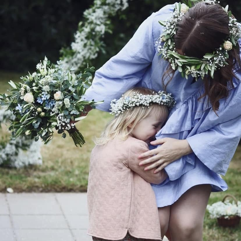 Mor og barn med blomsterkranse ved bryllupsceremoni