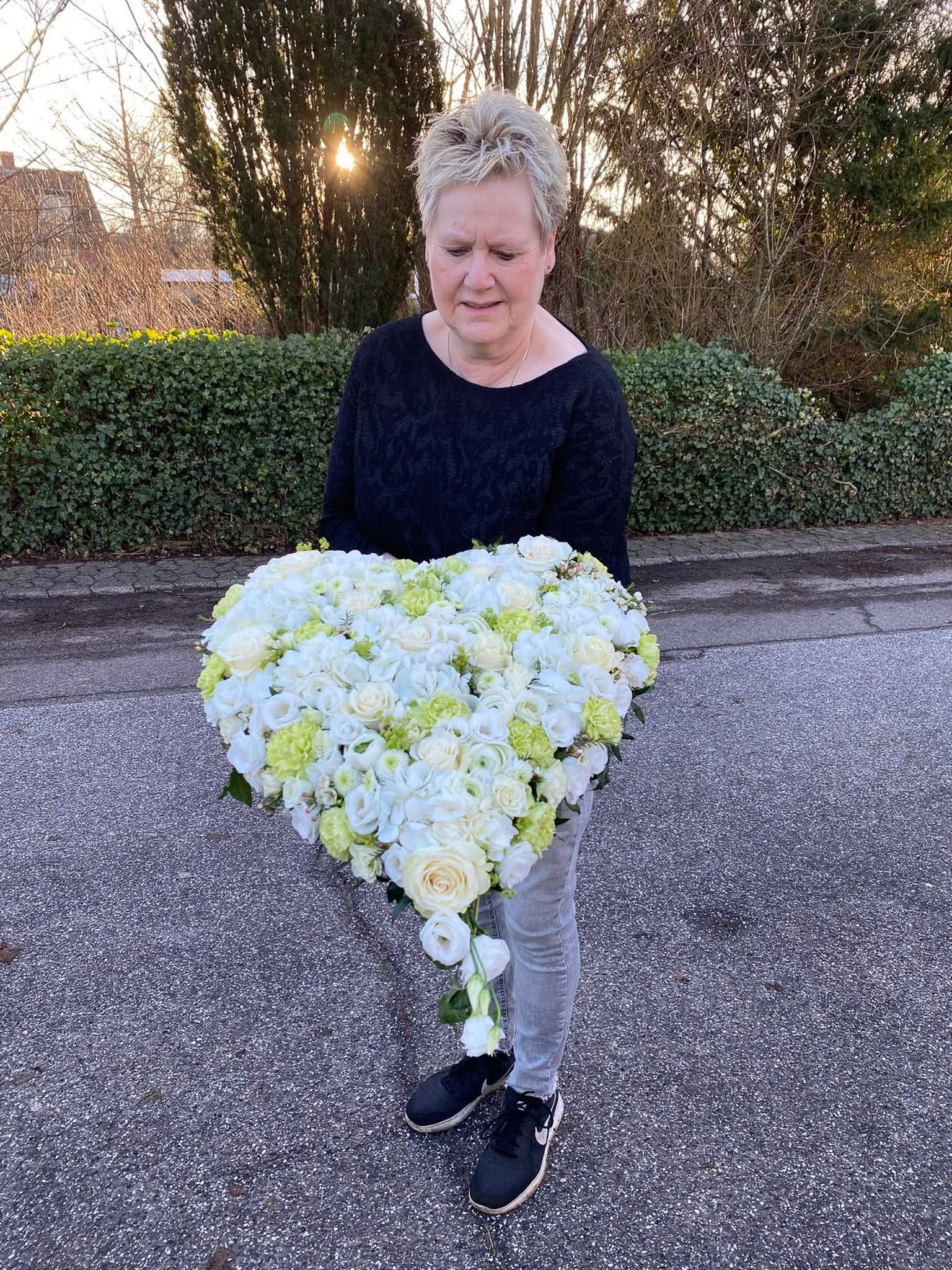 Hvidt og cremefarvet hjerte holdt af blomsterhandler
