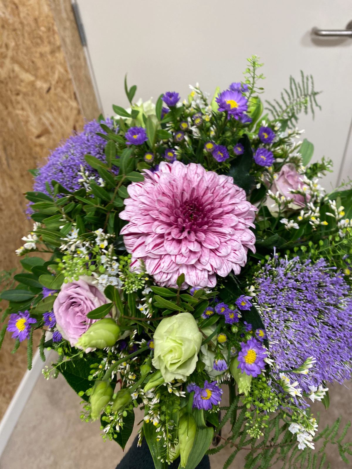 Farverig buket med lilla, rosa og hvide blomster.