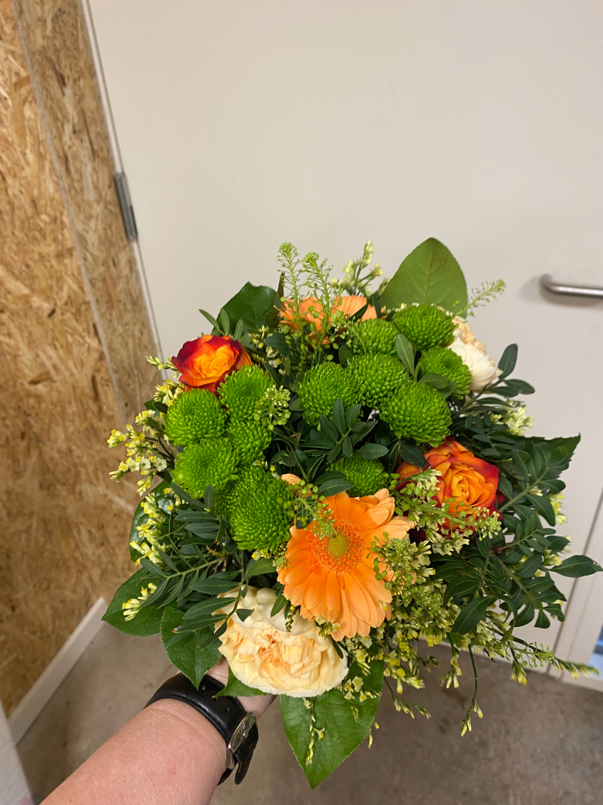 Grøn og orange buket med gerbera og lyse roser.