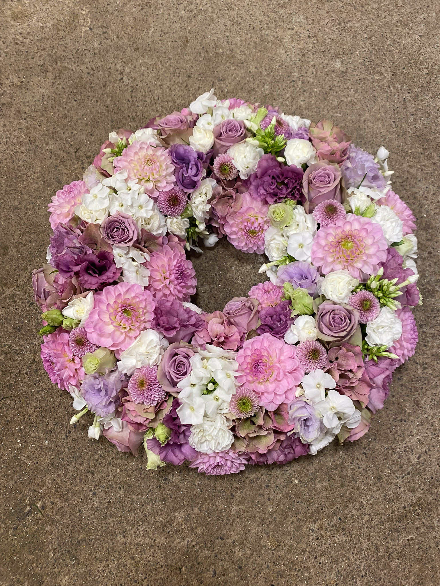 Pink og fersken krans holdt af blomsterhandler
