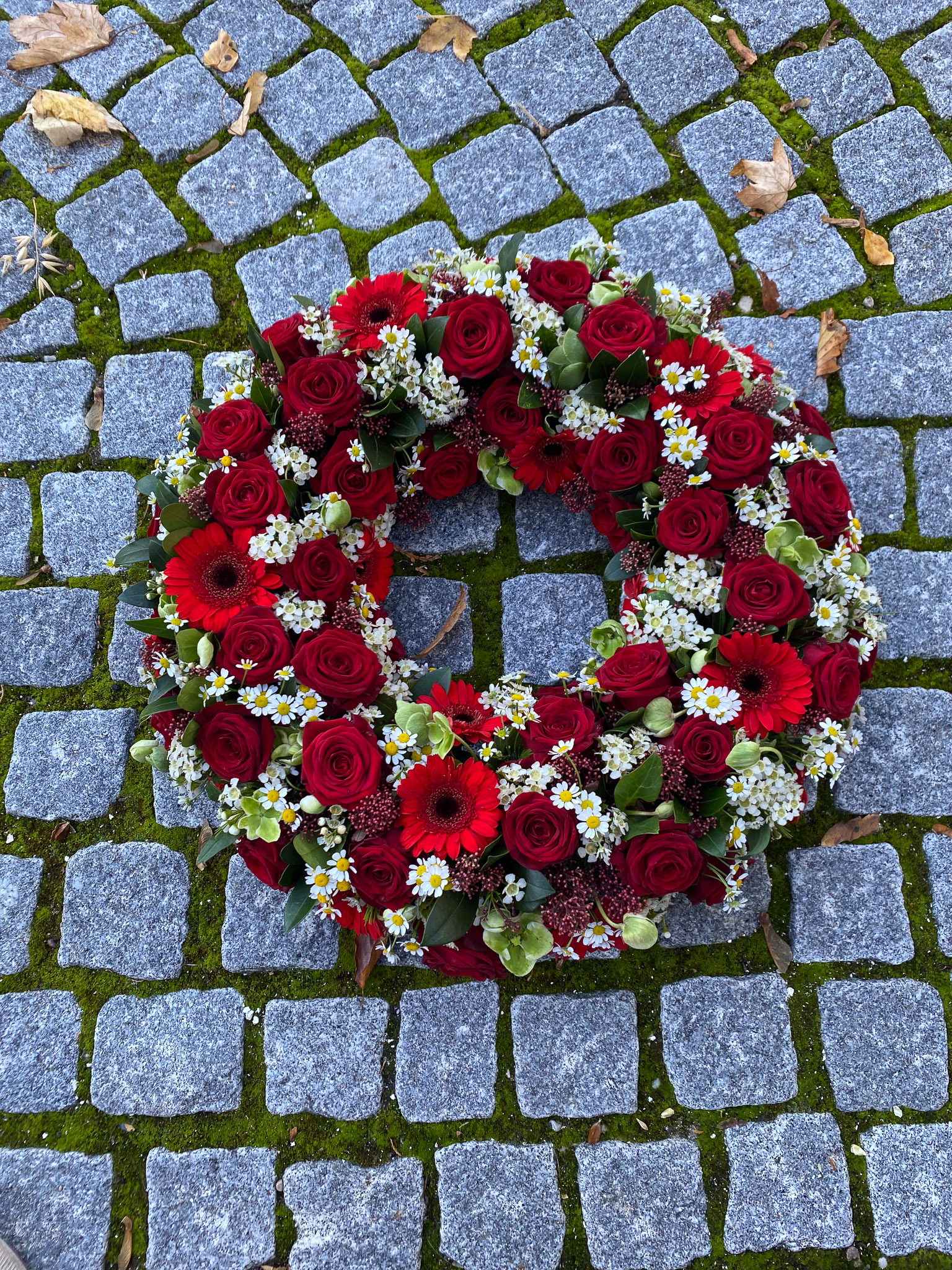 Hvid og rød blomsterkrans på stander