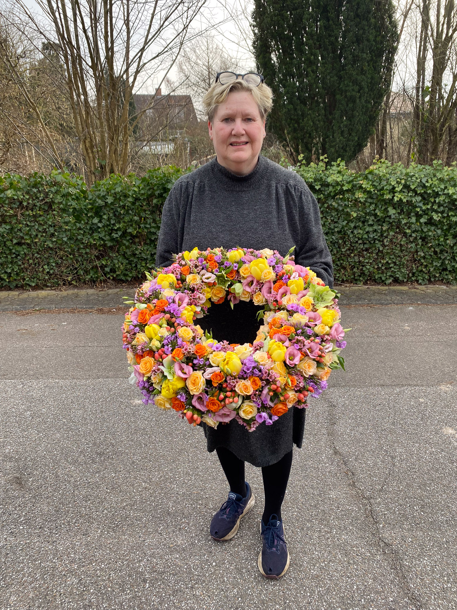 Rosa hjerteformet krans holdt af blomsterhandler