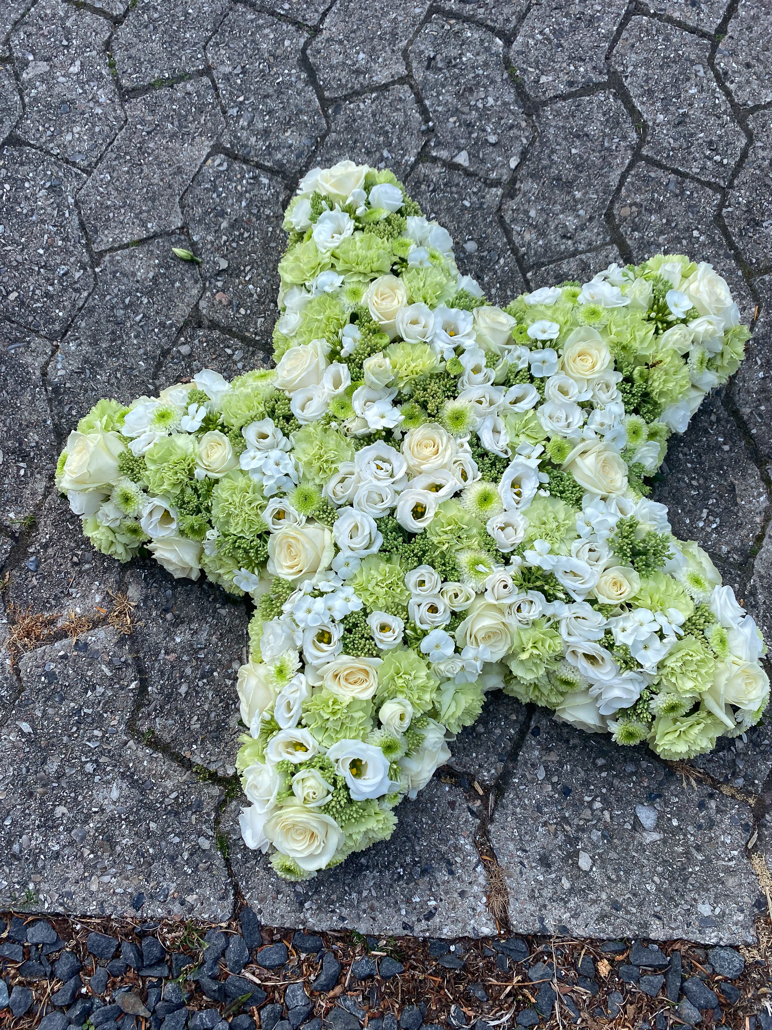 Lysegrønt og hvidt kors af blomster