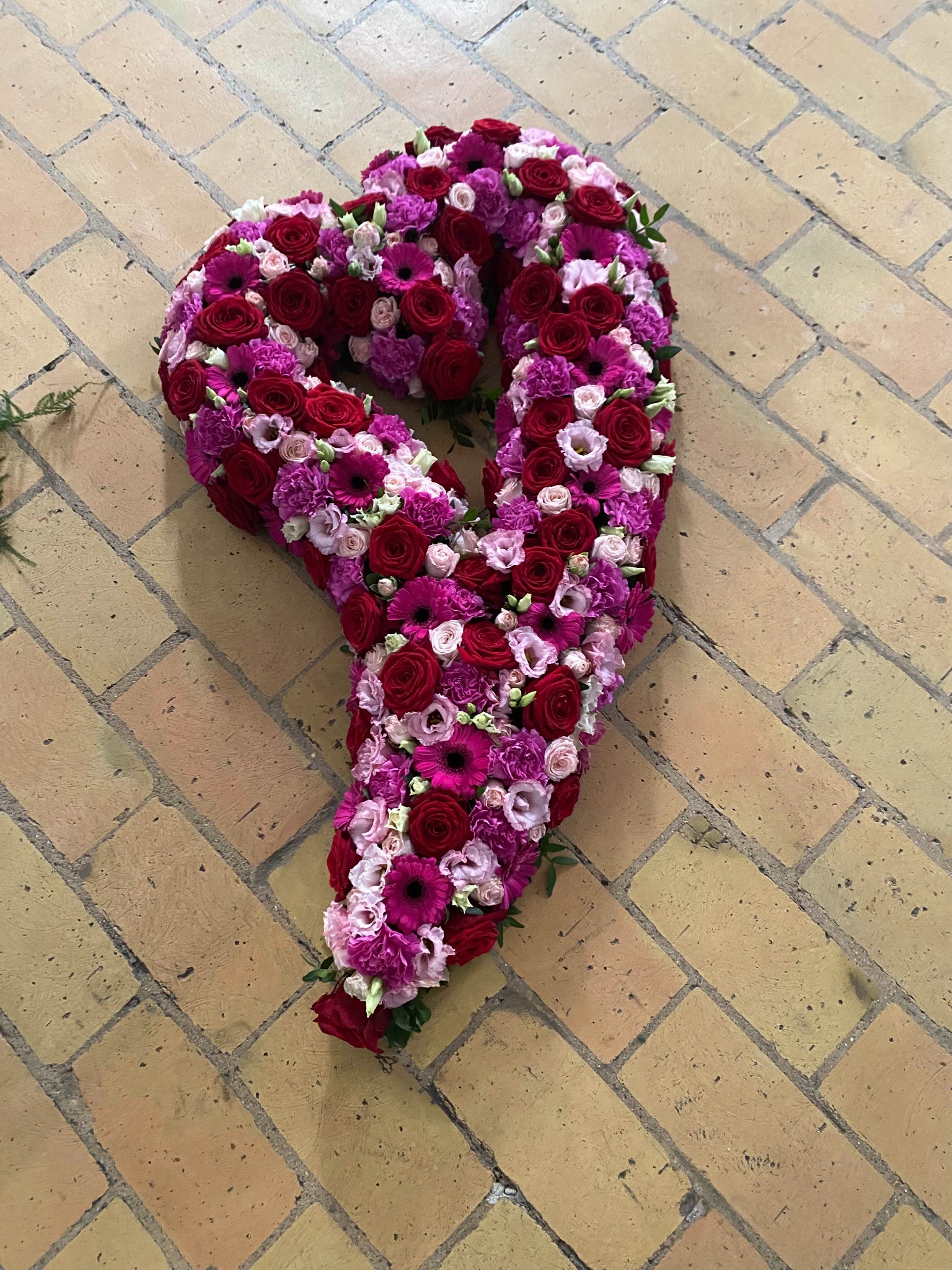 Åbent blomsterhjerte med mørkerøde og hvide blomster.