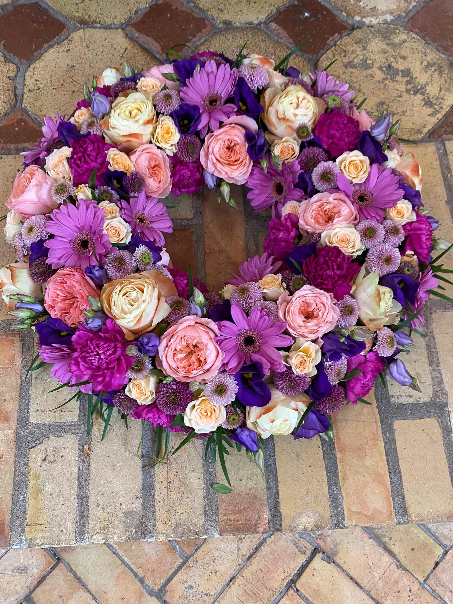 Pink og fersken krans holdt af blomsterhandler