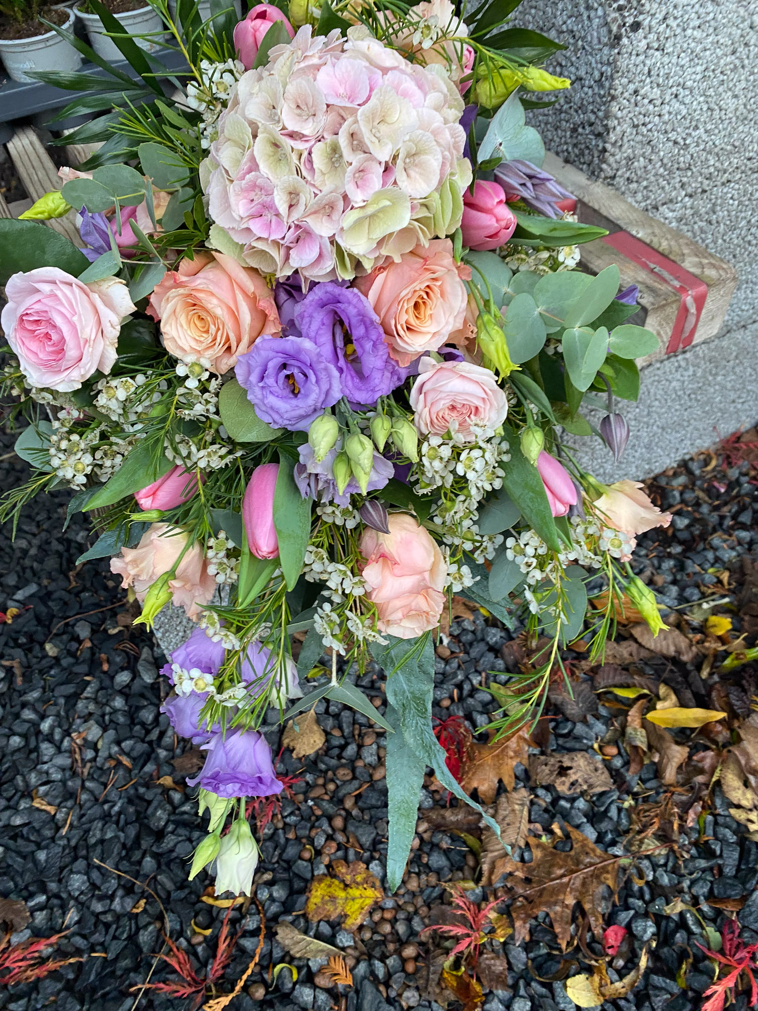 Bårebuket i pastelfarver med hortensia, ferskenfarvede roser og lilla eustoma