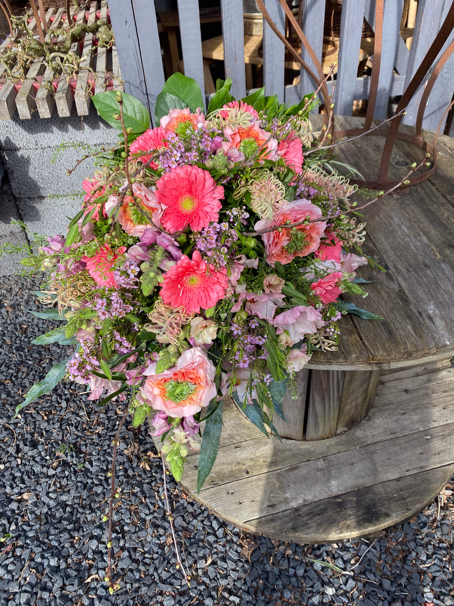 Rosa bårebuket med gerbera, haveroser og voksblomst